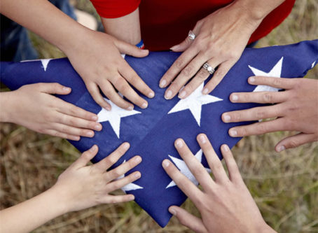 Folds of Honor, hands touching folded U.S. flag