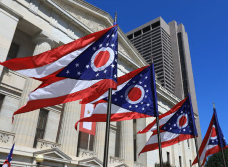 State of Ohio flags waving in front of the Statehouse in Columbus, OH
