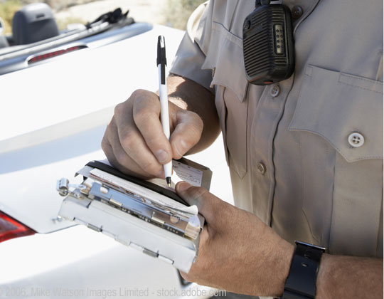 Law enforcement officer writing a traffic ticket, ticket quotas