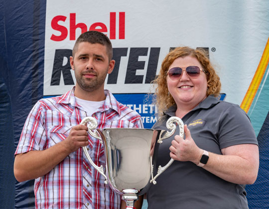 Keigan Nelson accepts the 2021 SuperRigs trophy from Heather Wales, Shell Rotella.