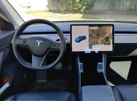 Tesla Model 3 electric car interior with large touch screen computer tablet dashboard