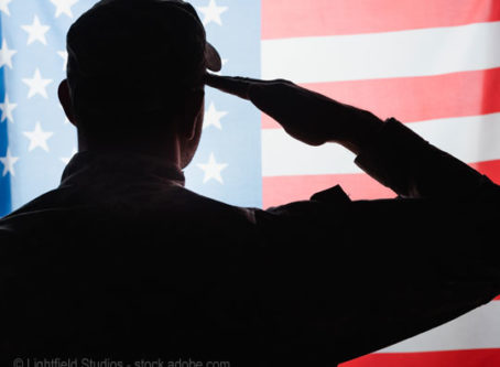 Military man salutes US flag