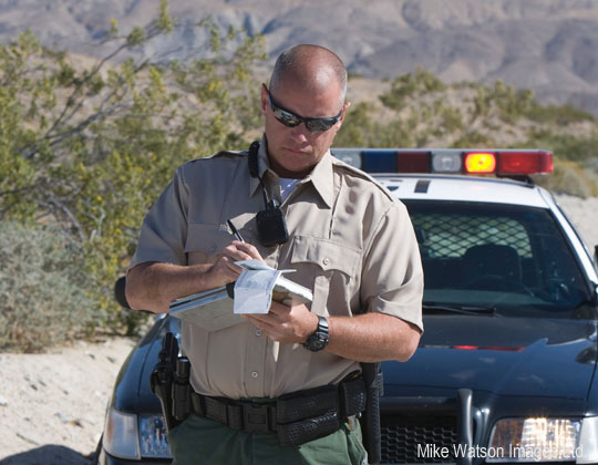 Officer writing a ticket. Photo by Mike Watson Images Ltd