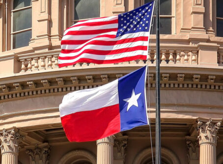American and Texas state flags at Texas capitol. Photo by CrackerClips Stock Media; Bryan Mullennix